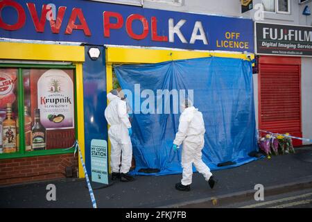 Forensic officers enter a shop on Waterloo Road, Smethwick, after a murder investigation has been launched when a teenager was chased into a shop and stabbed. West Midlands Police said the 17-year-old victim was found with knife wounds by a white Ford Focus which had crashed in the street on Saturday. The force said it is understood that 10 minutes before the victim was taken to hospital, he was chased into a shop in Waterloo Road and attacked with a knife. He was taken to hospital after being found with injuries but was pronounced dead around an hour later. Picture date: Sunday May 2, 2021. Stock Photo