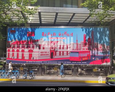 Shanghai, China. 19th Apr, 2021. A woman walks past a giant banners celebrating the 100th birthday of the Chinese Communist Party with a slogan '100 years of CCP fighting for a new path'. Credit: SOPA Images Limited/Alamy Live News Stock Photo