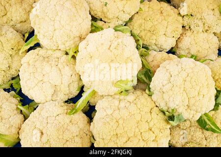 Bunch of fresh produce green organic cauliflower in pile at local farmers market. Suprmarket stand w/ healthy vegetables. Clean eating concept. Nutrit Stock Photo