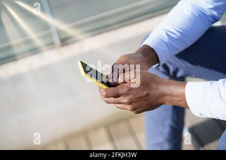 Hands of unrecognizable black man using a smartphone. Stock Photo