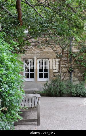 View of lawn and building facade with decorative planting from Hertford College Old Quad, Oxford, United Kingdom. Overcast Sky. Stock Photo