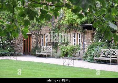 View of lawn and building facade with decorative planting from Hertford College Old Quad, Oxford, United Kingdom. Overcast Sky. Stock Photo