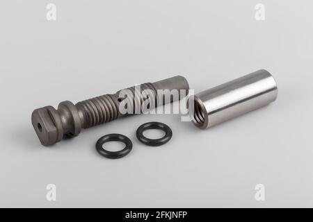 The repair kit for the spring from the pin bushing and gaskets lies on a gray background. Bushing and finger for truck repair. automotive components f Stock Photo