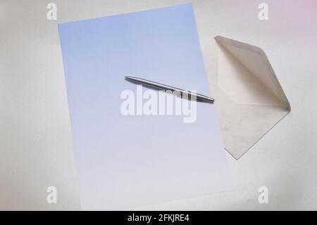 Letterhead with in a gradient blue color. on a silver background. A matching envelope and a ballpoint pen are also included. Large text field Stock Photo