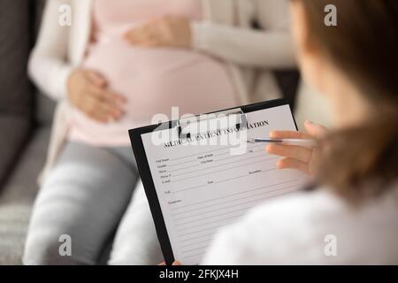 Close up of doctor consult pregnant woman in clinic Stock Photo