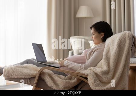 Young pregnant woman relax at home using laptop Stock Photo