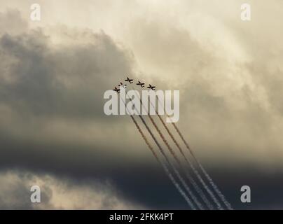 Jets flying in formation through a dark cloudy sky Stock Photo