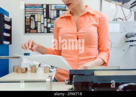 Worker checking design or a print to be run on printing machine Stock Photo