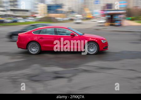 Ukraine, Kyiv - 26 April 2021: Red Audi A5 car moving on the street. Editorial Stock Photo