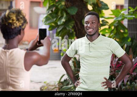Happy couple taking photos with a smart phone on vacation in the city Stock Photo