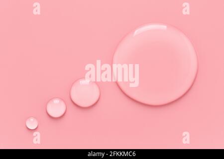 Water drops in speech bubble shape on pink background. Stock Photo