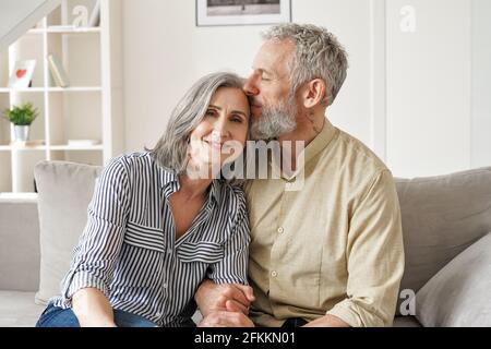Happy affectionate classy older mature couple bonding with eyes closed at home. Stock Photo