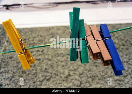 Closeup photo of some plastic cloth clips on a wire. Shot on Fujicolor 200 film. Stock Photo