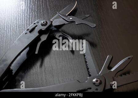 Black multi tool on wooden table close up Stock Photo