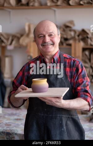 Senior happy hispanic craftsman standing in studio. Stock Photo