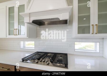An interior of a modern kitchen with a hood over the oven Stock Photo