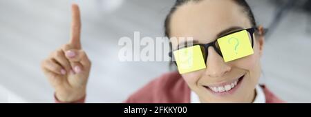 Woman has colored stickers with question mark on her glasses Stock Photo