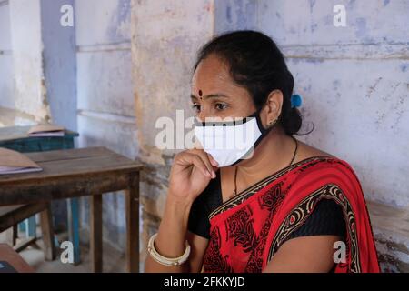 A portrait of a tired Indian female teacher in face mask during Covid-19 pandemic Stock Photo