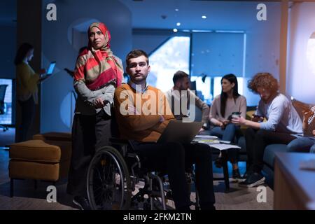 Handicapped young man with colleagues working in office. Disability and business success concept Stock Photo