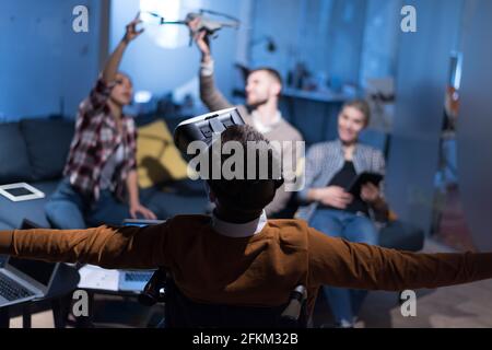 Disabiliti concept. Diverse group of architects witho one in wheelchair working in coworking office using modern technology. Stock Photo