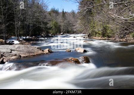 An early spring long exposure view of the Sacandaga River in the Adirondack Mountains, NY wilderness Stock Photo