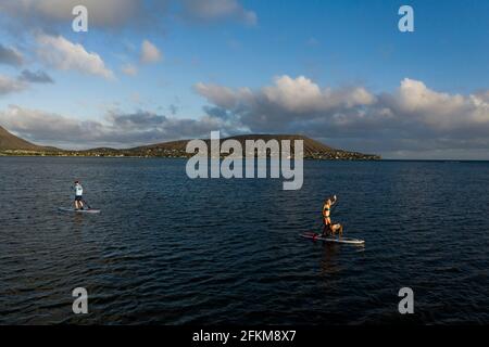 Two people using stand up paddleboards in front of Diamond Head Stock Photo