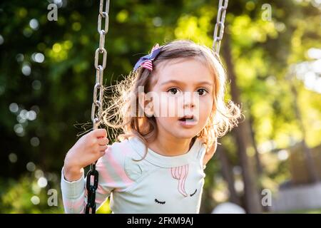 Little Girl on Swing with Patriotic Barrette Stock Photo