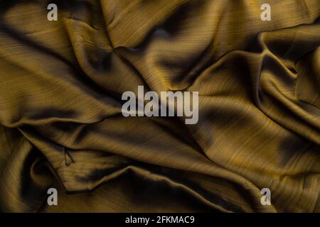 Fragment of yellow and green tissue. Side view, synthetic textile background and texture. wave concept, abstract. Stock Photo