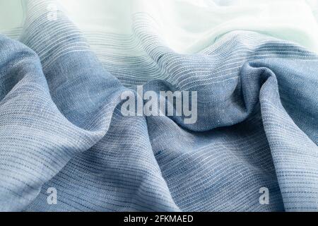 Fragment of blue linen tissue. Side view, natural textile background and texture. wave concept, abstract. Stock Photo