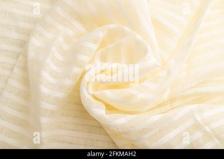 Fragment of white linen tissue. Top view, flat lay, natural textile background and texture. wave concept, abstract, spiral form. Stock Photo