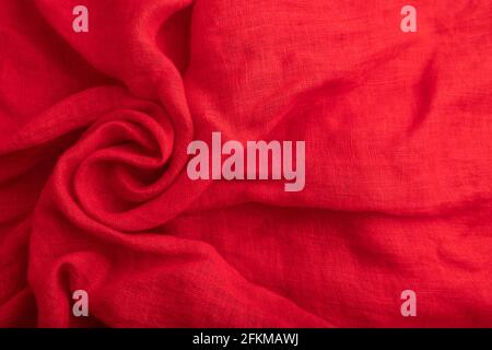Fragment of red silk tissue. Top view, flat lay, natural textile background and texture. wave concept, abstract, spiral form. Stock Photo