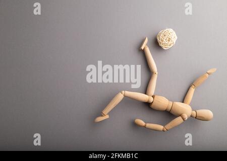 Wooden mannequin playing football on gray pastel background. copy space, isolated, sports concept. Stock Photo