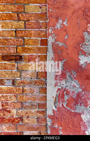 Old wall, brick wall next to red wall with crumbling paint, Venice, Italy Stock Photo