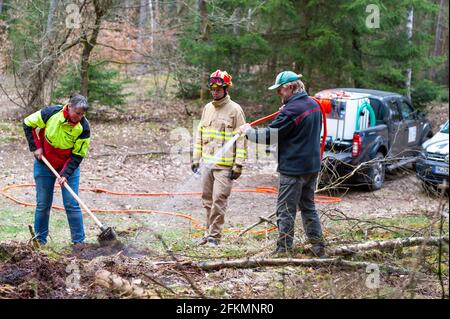 Oerrel, Germany. 22nd Apr, 2021. Steffen Hartig (centre), from the PYRECO company, instructs the two foresters Elke Urbansky (left) and Norbert Voss (right) in the handling of the extinguishing module, which is mounted on a pickup truck. The Lower Saxony State Forests are testing an extinguishing tank for quickly fighting forest fires. With a volume of 600 litres, it fits on any pickup truck or trailer. Credit: Philipp Schulze/dpa/Ģ����ý Live News Stock Photo