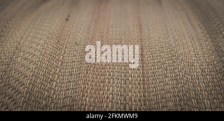BANNER Real nature background. Blur effect. Close-up Woven method bamboo cane straw pattern texture mat. East Asia traditions. Calm spa warm mood Stock Photo