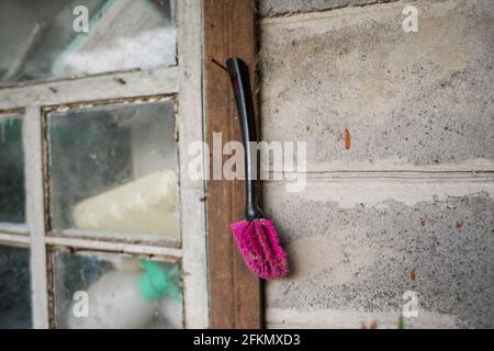 an old brush hanging on the wall of an old house Stock Photo