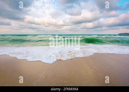 evening landscape at the sea. beautiful nature scenery. summer vacation concept. dramatic sky above the horizon. waves run on sandy beach Stock Photo