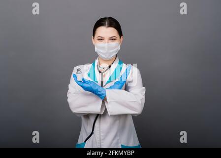 Beautiful female doctor in protective mask looking away and thinking about something. Stock Photo