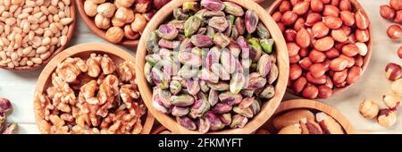 Nuts panorama, overhead flat lay shot. Pistachios, walnuts, peanuts etc Stock Photo
