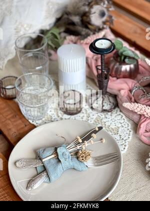 Festive table setting with sprigs of dried flowers and decorative elements. Stock Photo