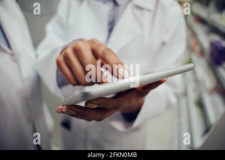 Young female pharmacist finger touching digital tablet while working Stock Photo