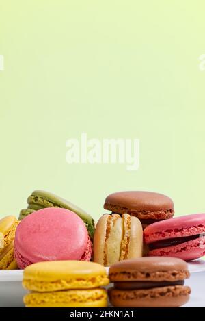 French dessert macaron isolated on green background. Modern Macarons on colorful background. Stock Photo