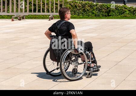 Krasnodar, Russia - May 2 2021: Man in a wheelchair in a park. Sunny day. No Architectural barrier Stock Photo