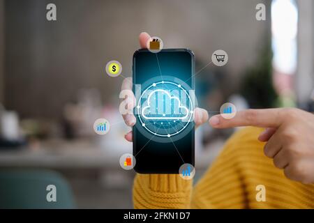 Female using smartphone with icon graphic cloud cyber security network of connected devices and personal data security. Stock Photo