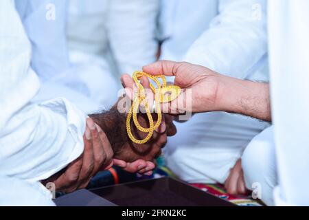 Muslim wedding nikah function in islam groom handing over gold to groom father Stock Photo