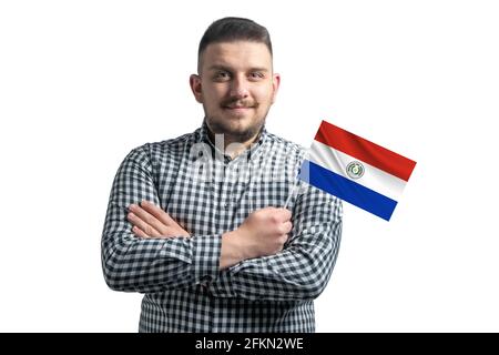 White guy holding a flag of Paraguay smiling confident with crossed arms isolated on a white background. Stock Photo
