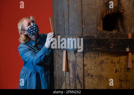 Alice Roberts-Pratt, Interpretation Officer at the National Museum of the Royal Navy, studies a section of the original wooden foremast from HMS Victory with a hole in the middle made by a cannon ball during the Battle of Trafalgar. The piece has been lent by Queen Elizabeth II from the Royal Collection and is one of the main exhibits on display in the new HMS Victory: The Nation's Flagship gallery at Portsmouth Historic Dockyard, which will open to the public on May 17th. Picture date: Friday April 30, 2021. Stock Photo