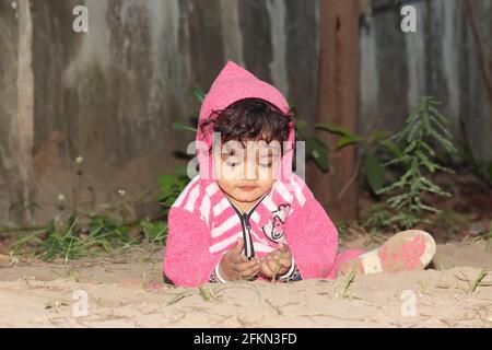 Close-up portrait of An Asian little baby boy child playing on sandy ground. Concept to childhood, beautiful indian child playing, Childhood memories. Stock Photo