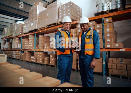Happy colleagues discussing something using digital tablet Stock Photo