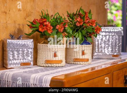 Aluminum boxes and decorative handmade vases with red alstroemeria flowers in the living room Stock Photo